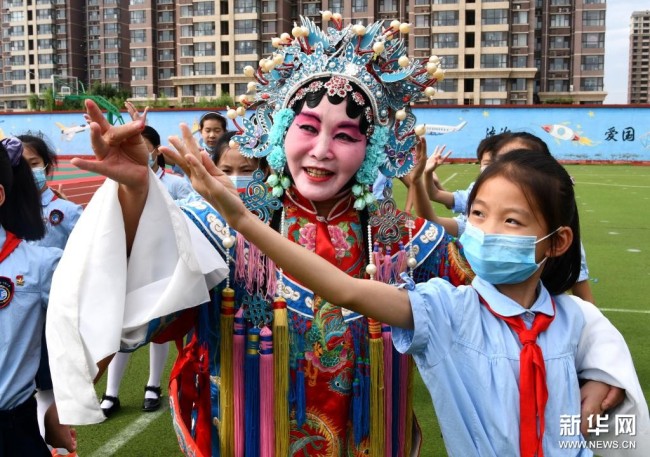 9月6日，在河北省石家庄市栾城区宏远路小学，丝弦演员在教学生们戏曲的基本动作。