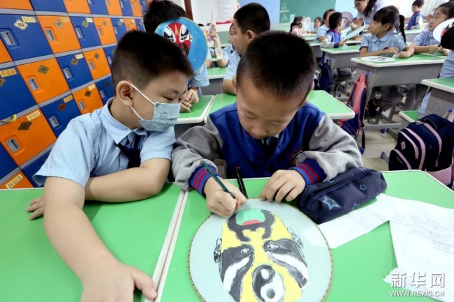 9月6日，在河北省石家庄市栾城区宏远路小学，学生们在绘制扇子脸谱。 新华社发（李明发 摄）