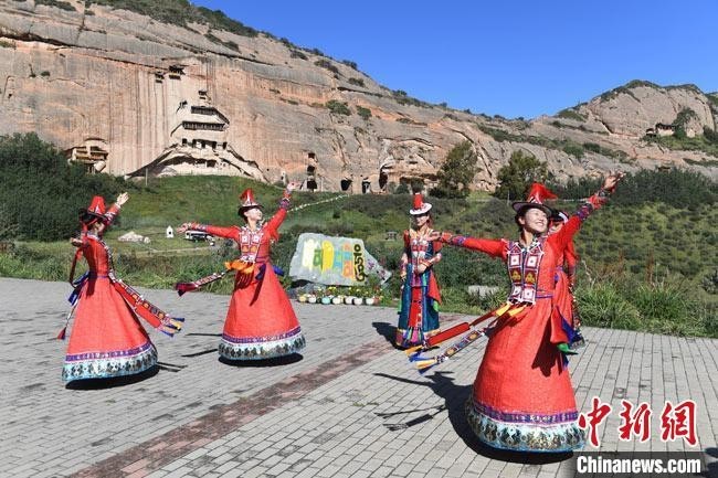 　　图为2019年9月，裕固族妇女身着民族盛装在马蹄寺前一展舞姿。（资料图）　杨艳敏　摄