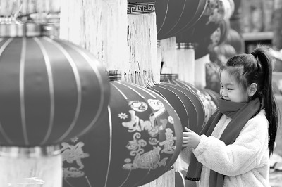 1月30日，小朋友在山东省潍坊高密市年货大集上挑选红灯笼。新华社发